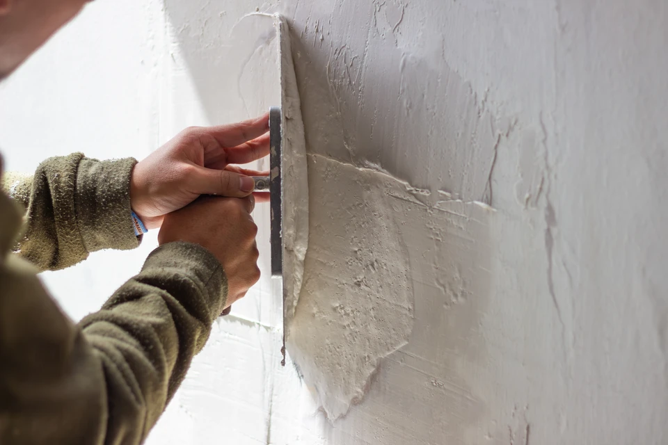 Olivier, un chef de projet en tenue professionnelle, discutant attentivement avec un propriétaire de maison dans un intérieur en rénovation. Olivier tient un document ou un carnet de suivi des travaux, illustrant l'échange constructif et la prise en charge personnalisée du projet de début à fin. L'arrière-plan montre un chantier de rénovation en cours (murs, carrelage ou revêtements visibles), et l'atmosphère doit transmettre la confiance, la professionnalité et la relation de proximité.