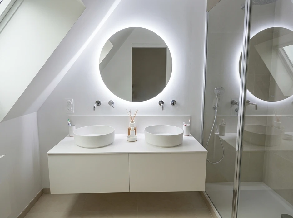 Salle de bains moderne avec double vasque encastrée sur meuble suspendu en bois foncé à 4 tiroirs, plan vasque en résine blanche