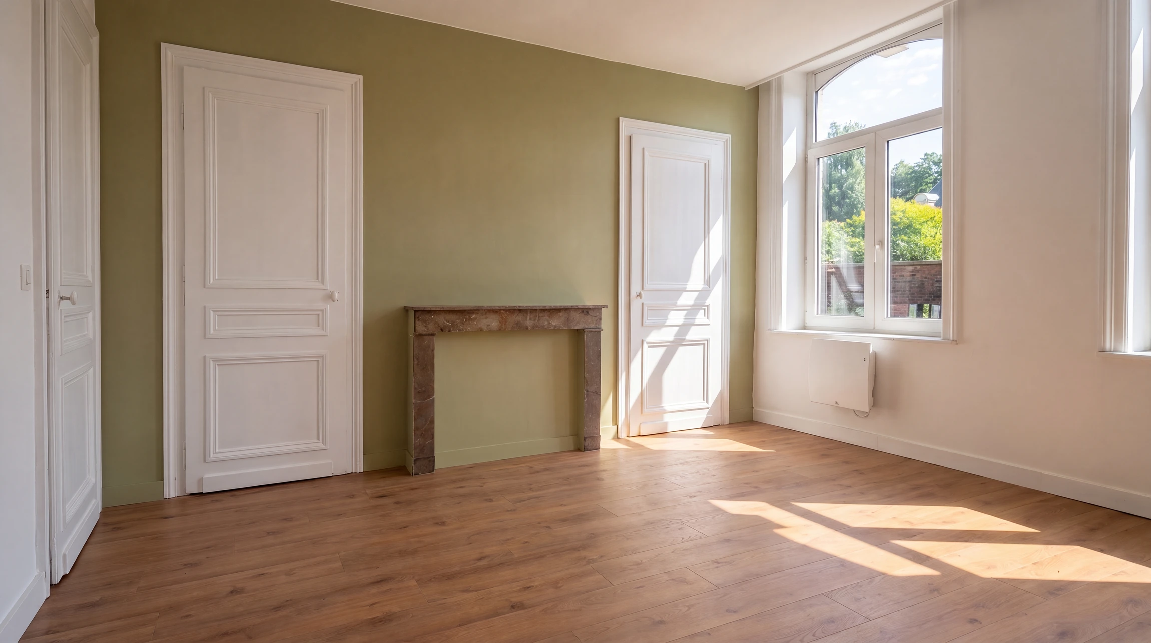 Travailleur en train de poser du carrelage sur sol intérieur, à genoux, portant des gants de protection jaunes et bleus