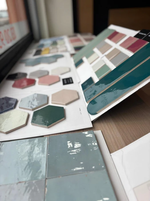 Showroom de salle de bain avec présentoir d'échantillons de revêtements de sol en vinyle LVT effet bois, déclinés en plusieurs teintes (gris, taupe, beige)