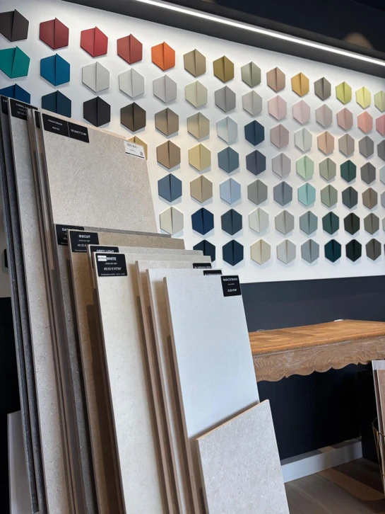 Showroom intérieur d'un magasin de revêtements de sol avec présentoirs exposant des échantillons de parquet, stratifié et carrelage
